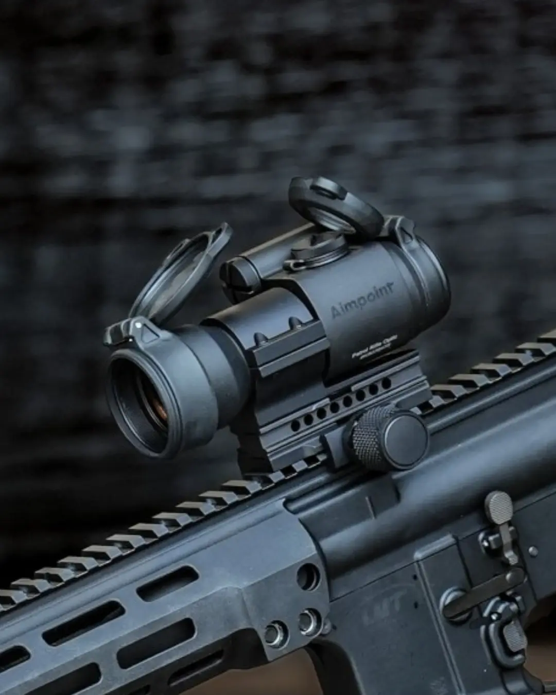 Close up of a rifle optic mounted on a tactical picatinny rail system
