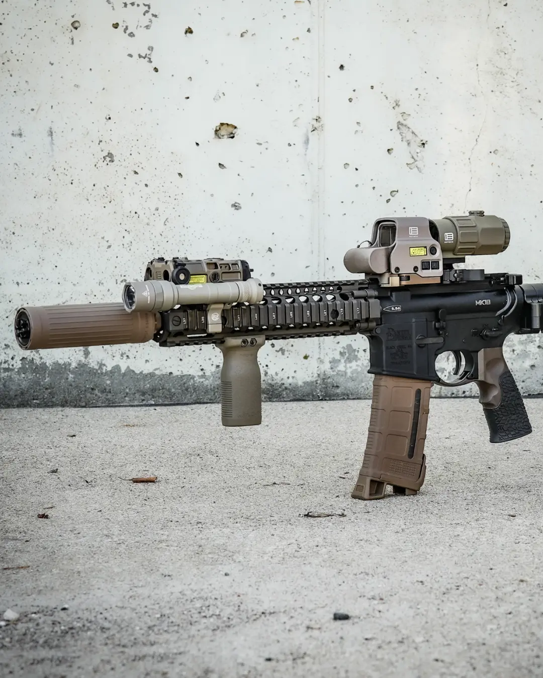 Rifle with multiple tactical accessories and upgrades mounted to the handguard